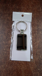 Angled view of rectangular metal keychain with black and silver finish
