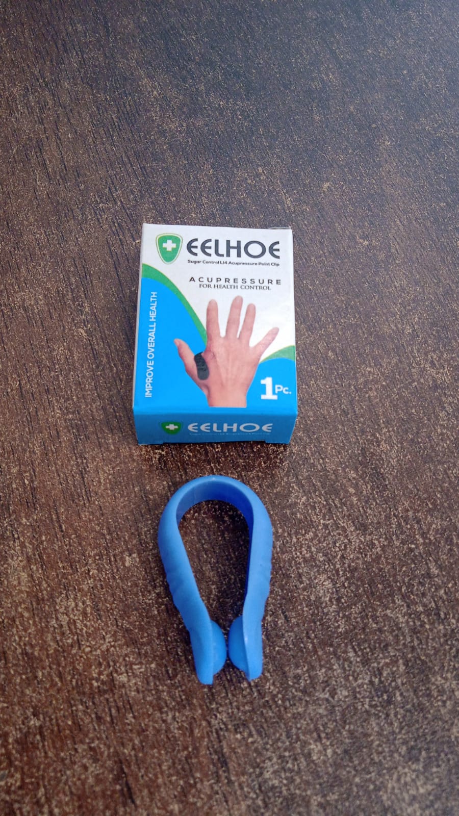 Lifestyle image of a person using the Acupressure Clip for natural pain relief while working.