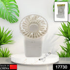 A person's hand holding the compact USB rechargeable fan for on-the-go relief.