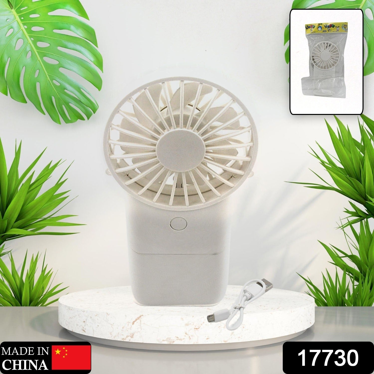 A person's hand holding the compact USB rechargeable fan for on-the-go relief.