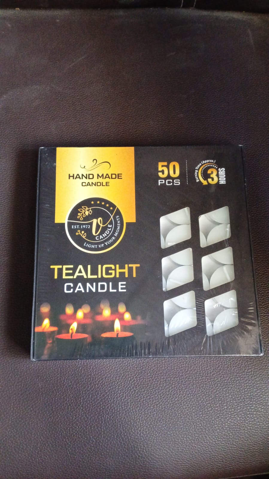 Overhead view of multiple tealight candles in a box.