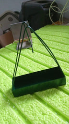 Triangular iron mosquito coil holder with a rustic finish, ready for use.