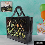 Angled view of black birthday gift bag with golden star pattern