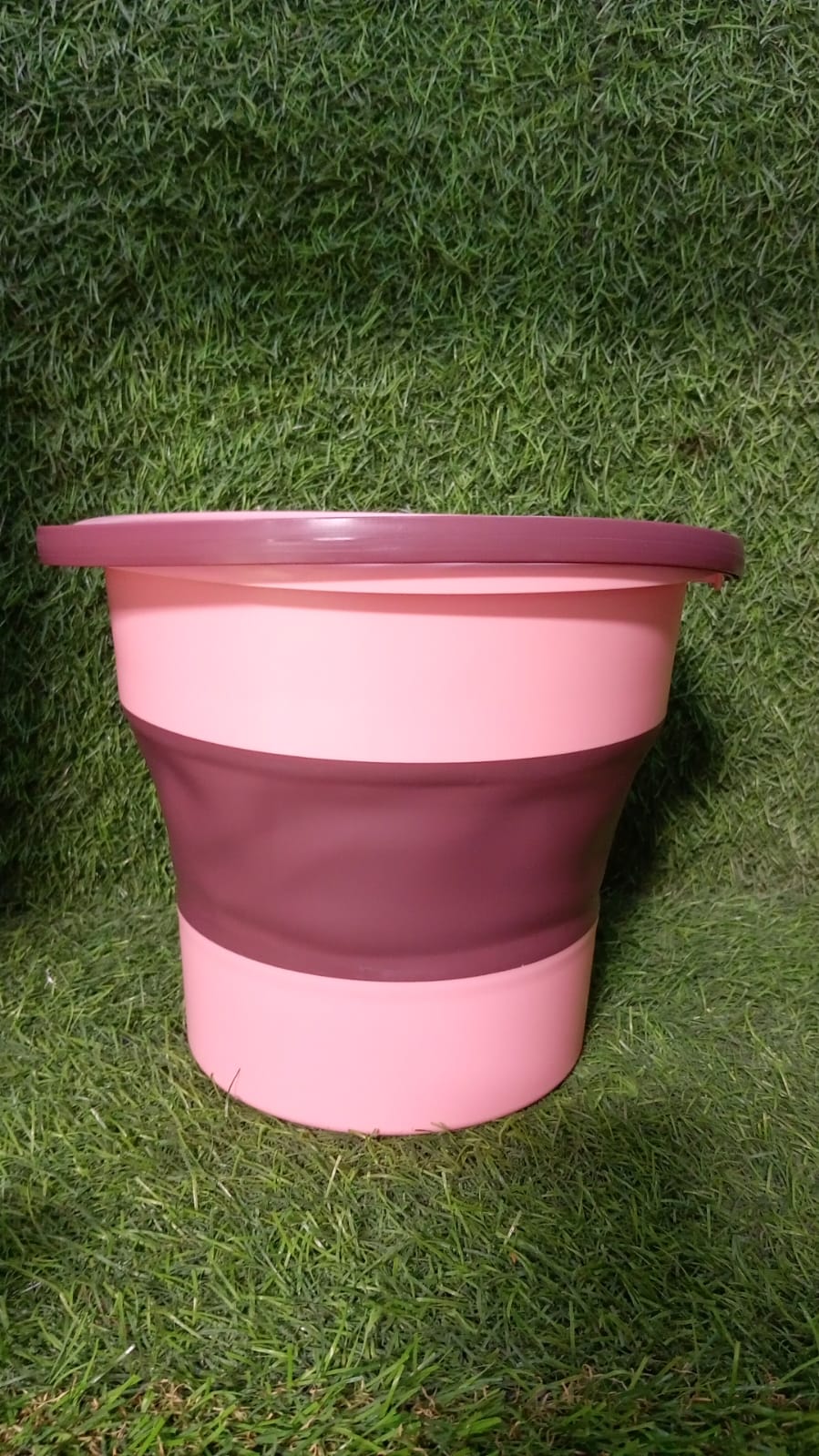 The compact foldable water bucket neatly collapsed for easy storage.