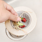 Silicone sink strainer basket filled with trapped food debris, preventing clogs.