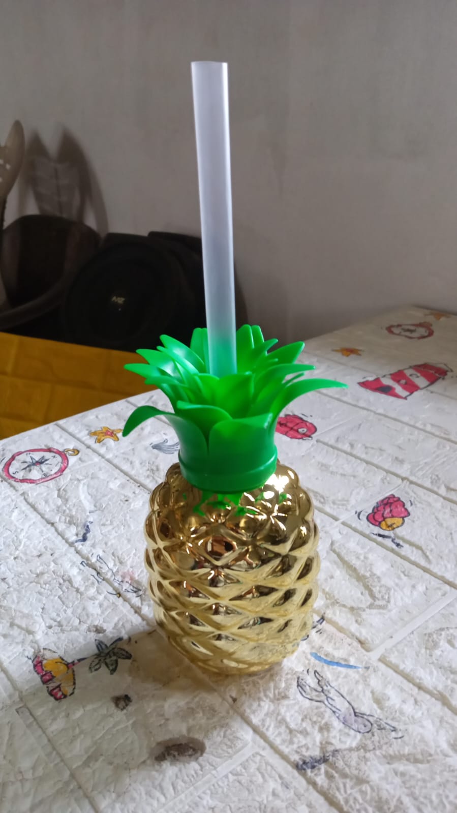 Isolated view of the plastic pineapple cup with straw on a plain background.