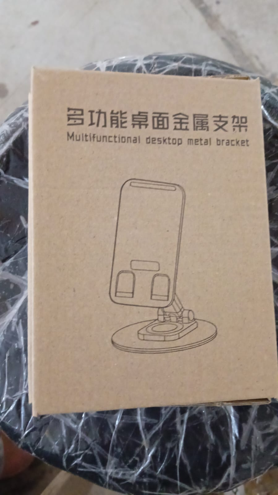The compact rotating mobile stand displayed from the front, illustrating its minimal footprint on a desk.