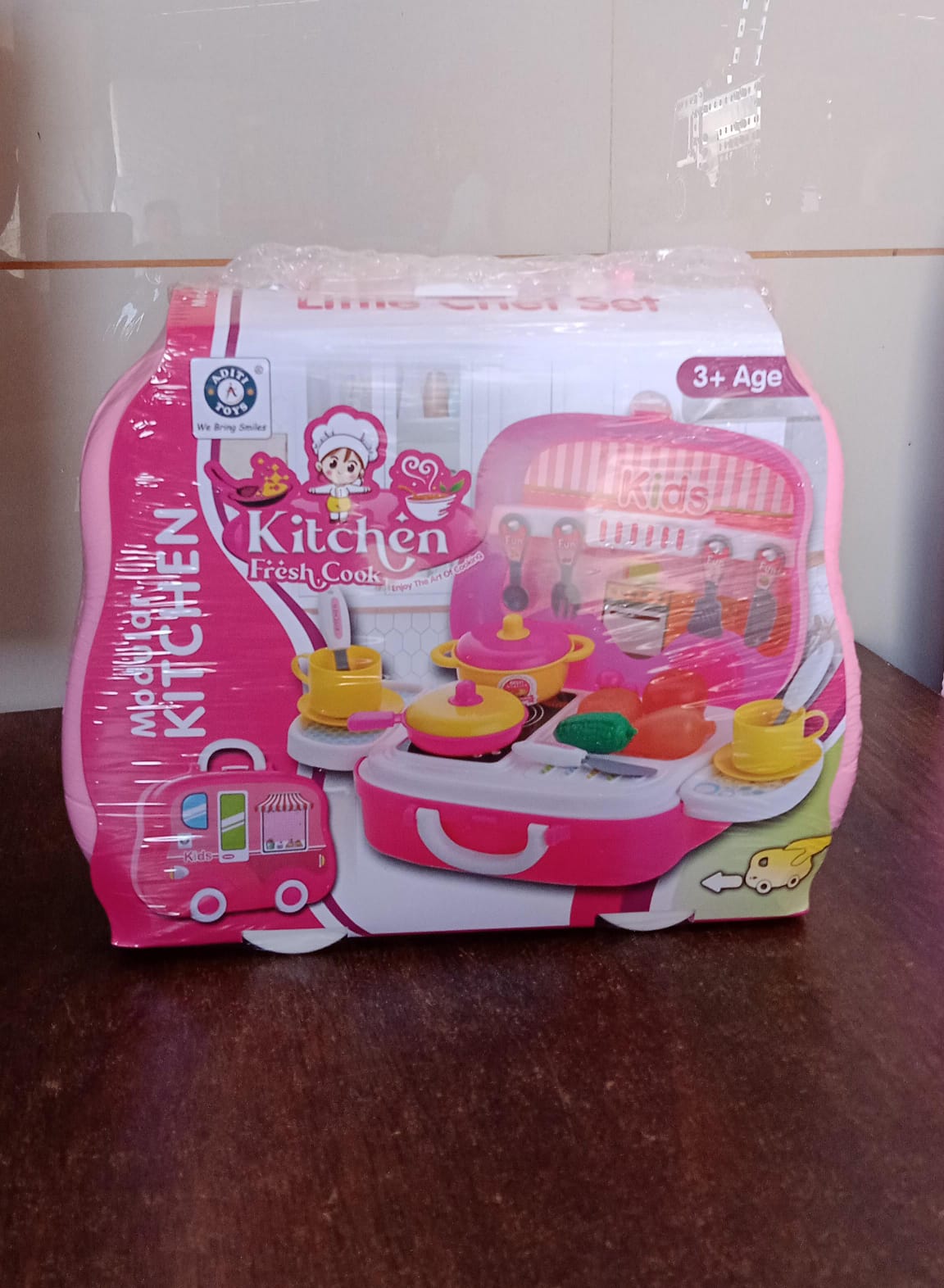 Child pulling the closed portable kids kitchen play set suitcase