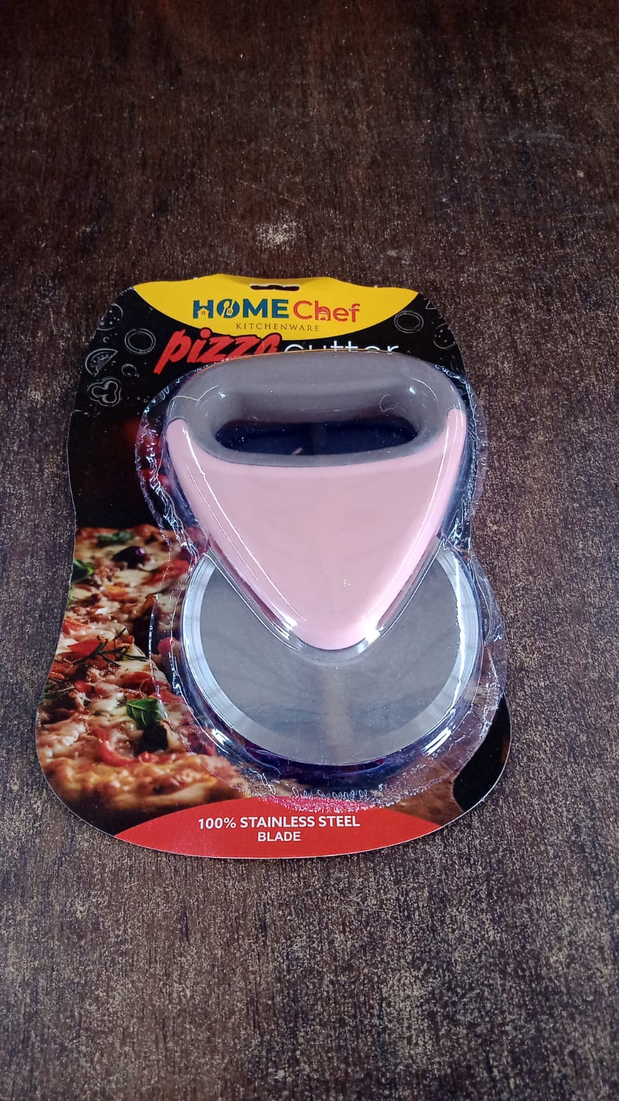 Stylish pink and brown ergonomic pizza cutter placed in kitchen setting