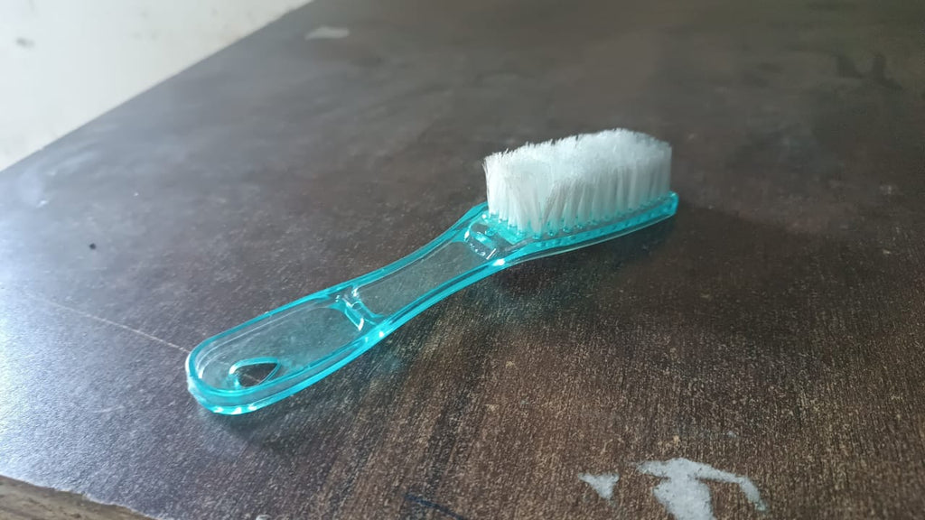 Plastic scrubbing brush featuring an ergonomic handle design.