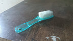 Plastic scrubbing brush featuring an ergonomic handle design.