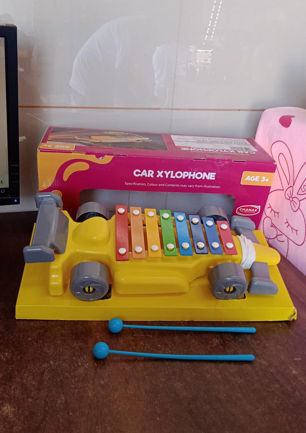Close-up of the precisely tuned, colorful xylophone bars on the car-shaped musical toy.