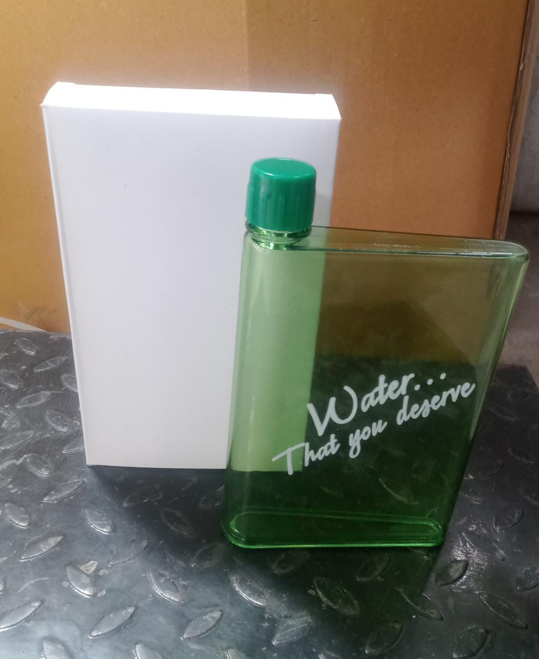 An individual holding the A5 Notebook Water Bottle, highlighting its comfortable grip and compact size.