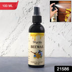 Spraying Beeswax Furniture Polish onto a wooden surface to nourish and protect the wood.
