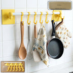 Wall mounted kitchen rack with adhesive hooks holding kitchen accessories