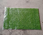 Display of the soft and durable 58x38cm plastic grass, suitable for indoor and outdoor use.
