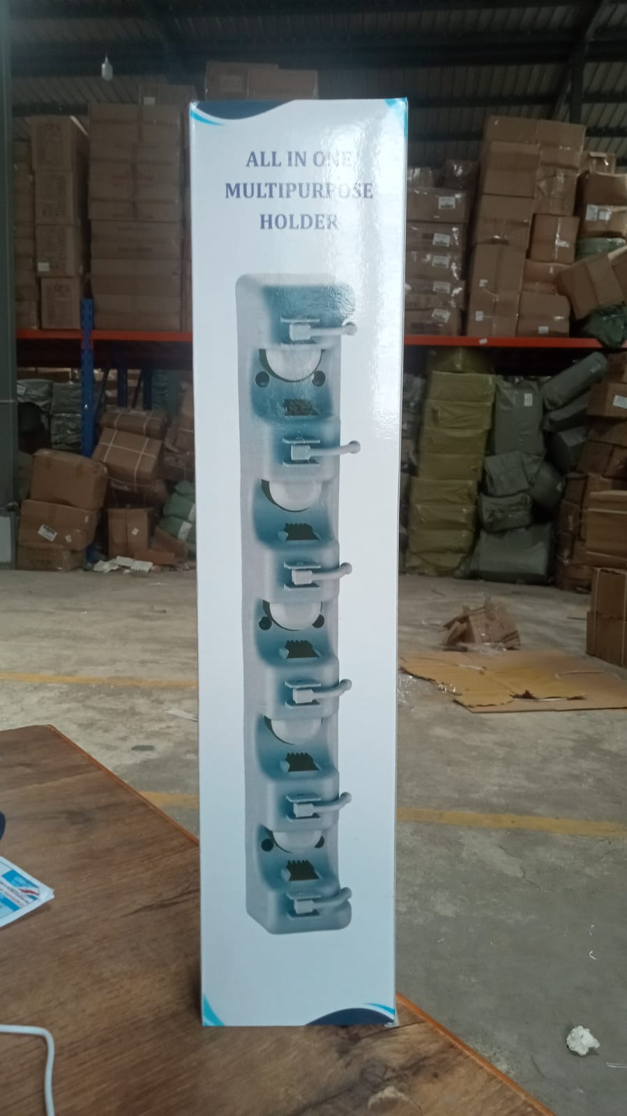 The versatile wall mounted mop holder shown with various cleaning and garden tools.