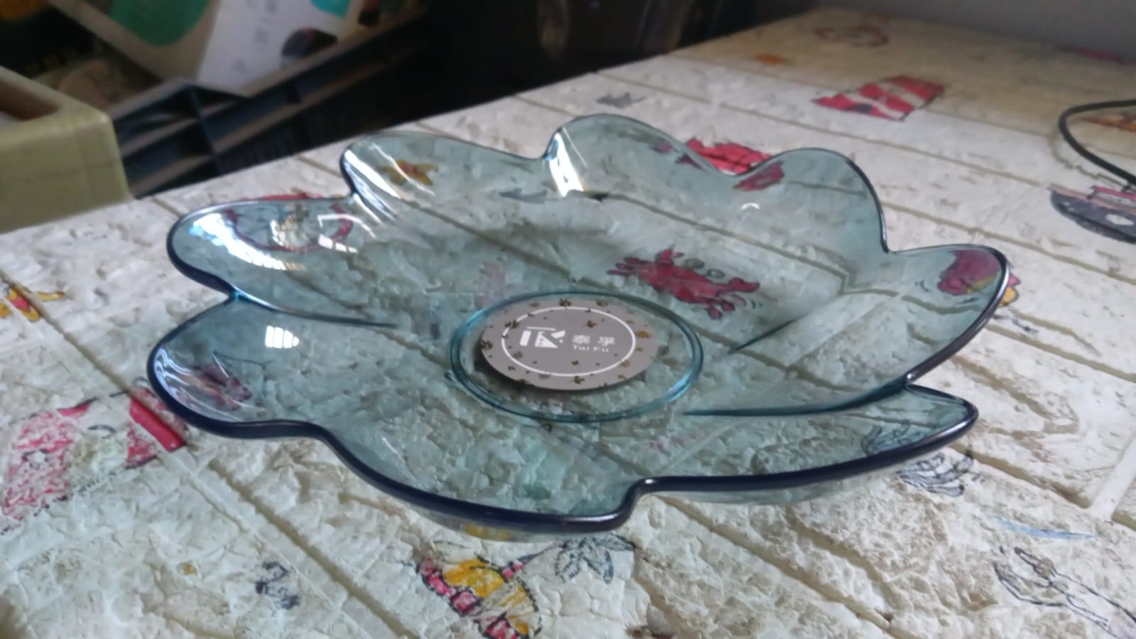 An overhead view of a single flower shaped kids plastic plate, showcasing its unique and attractive design.