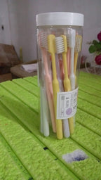 The complete 20-piece soft plastic toothbrush set with its clear portable round storage box.