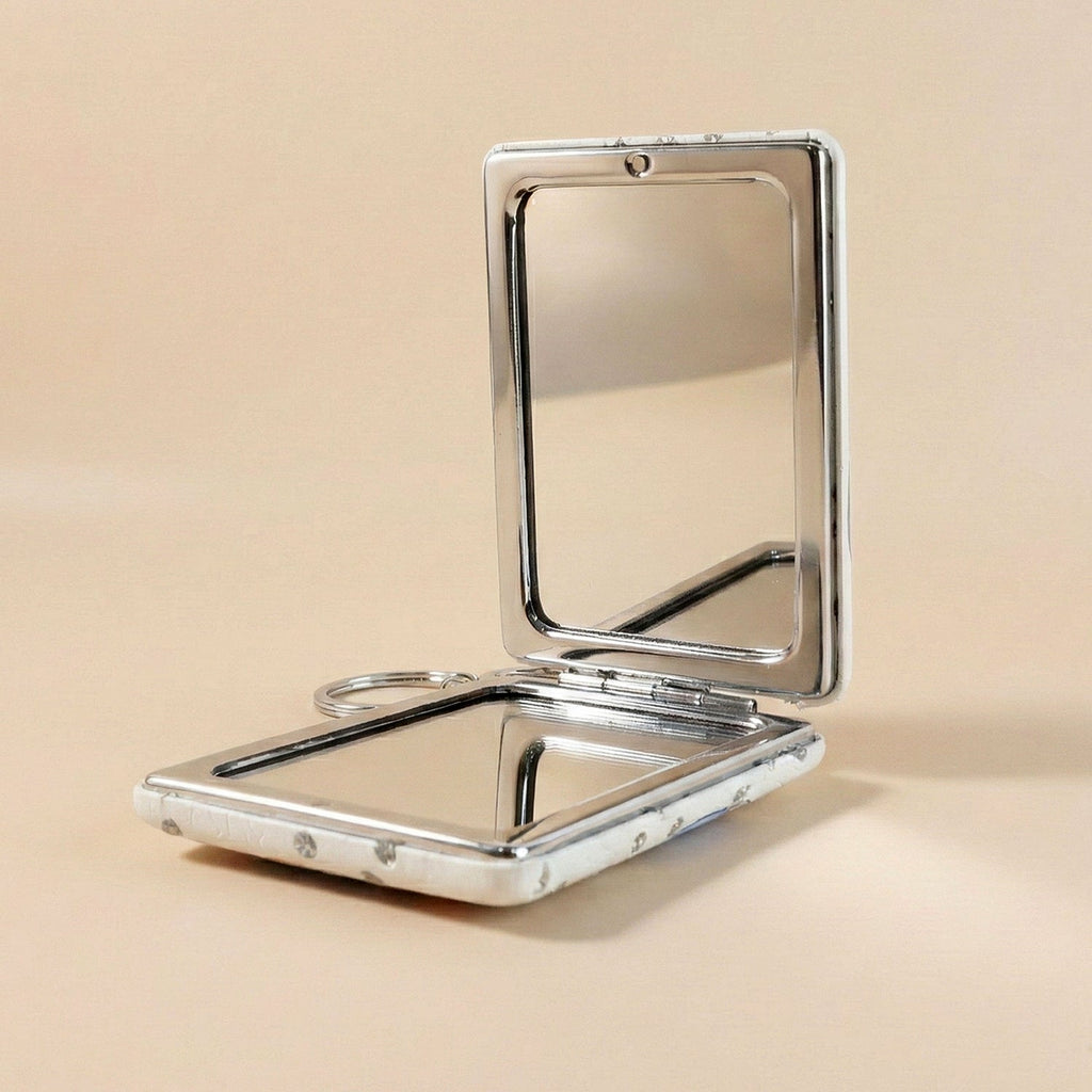 Foldable compact mirror keychain demonstrating dual-sided mirrors