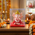 Hand-moving small Ganesha idol in vibrant red and gold colors on display