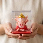 Front view of compact small Ganesha idol with rotating hands in red and gold