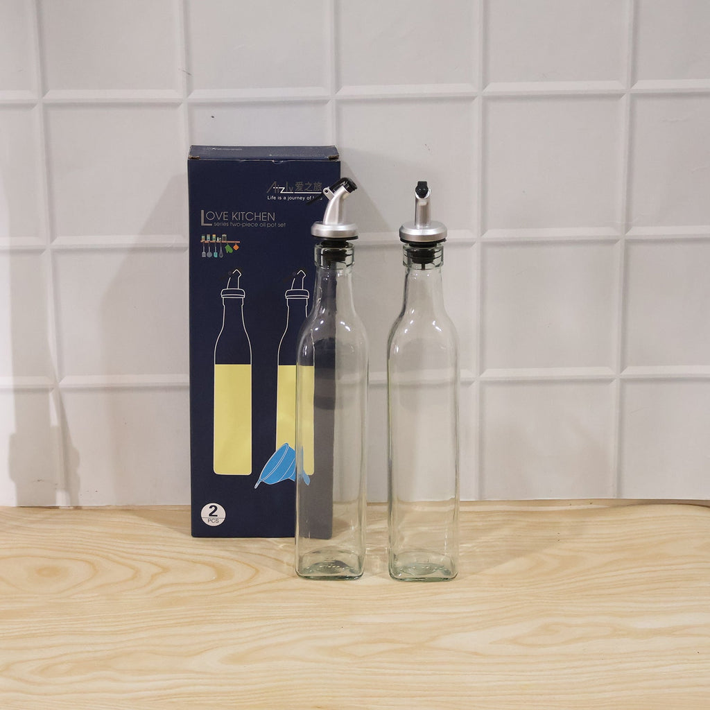 Packaged set of two transparent glass oil dispensers with lids