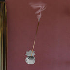 Wall-mounted agarbatti holder in silver mounted inside pooja room