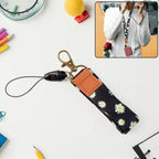Floral print neck lanyard holding keys and ID badge with daisy design