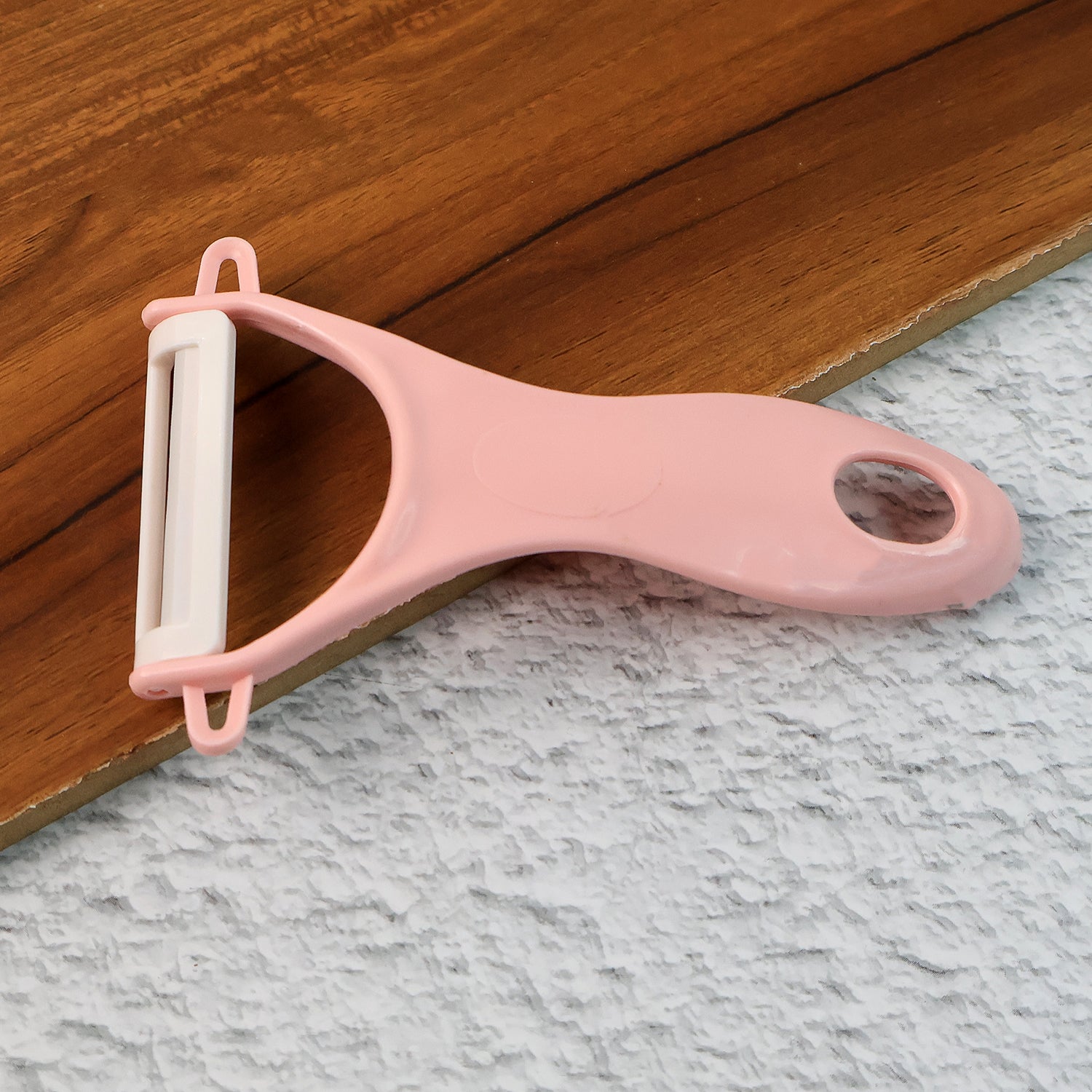 Sharp vegetable peeler effortlessly peeling a fresh orange carrot.