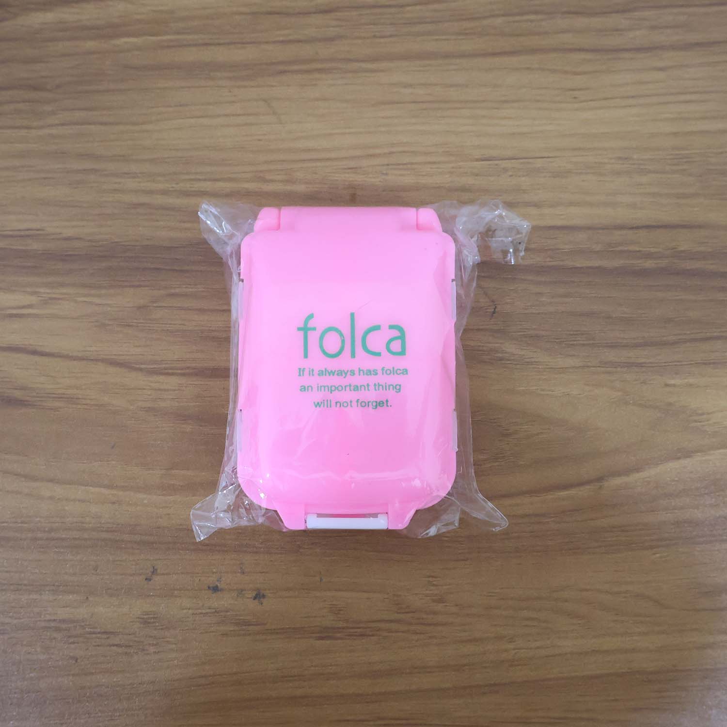 Lifestyle image showing portable pink pill organizer in use