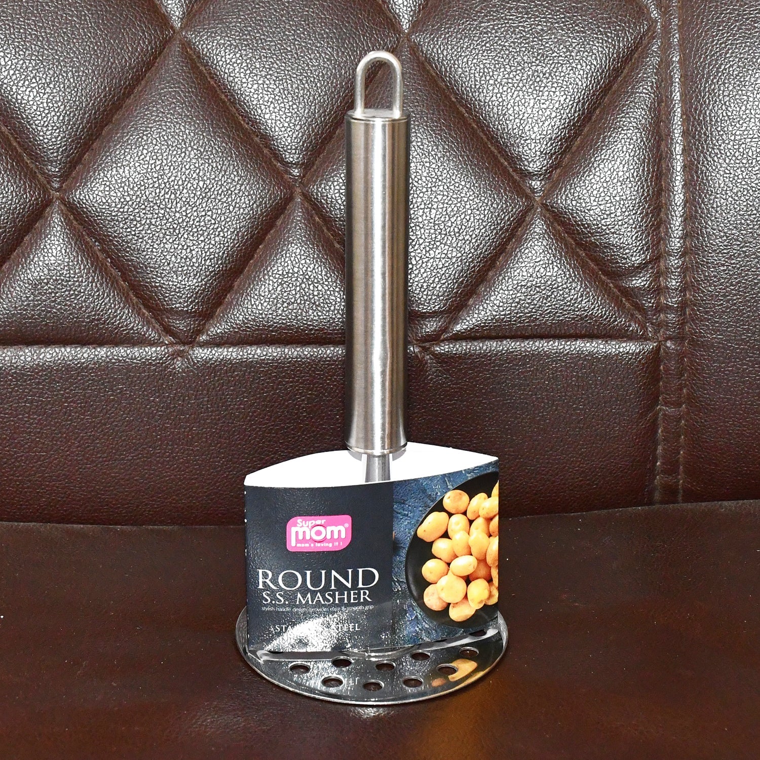Kitchen scene showing stainless steel potato masher in use