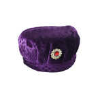 Boy wearing velvet traditional cap with stone brooch in festive setting