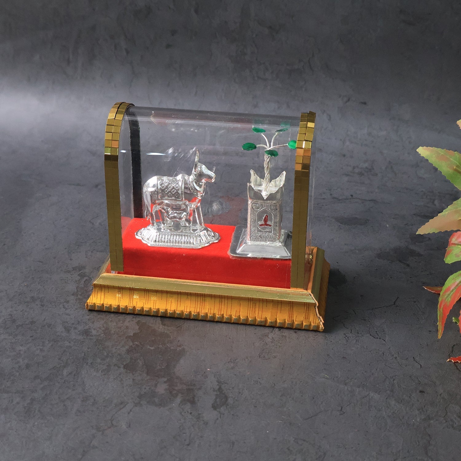 Close-up of Kamdhenu cow and Tulsi plant idol showing intricate silver plating