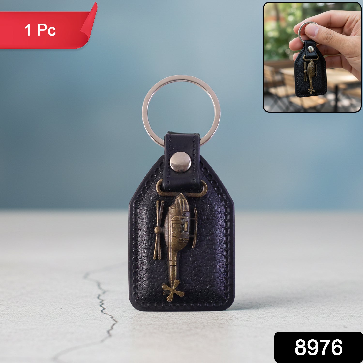 Close-up of metal sword emblem on leather finish keychain