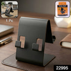 Black metal phone stand holding smartphone on desk for hands-free viewing