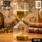 Side view of glass sand timer hourglass with flowing yellow sand