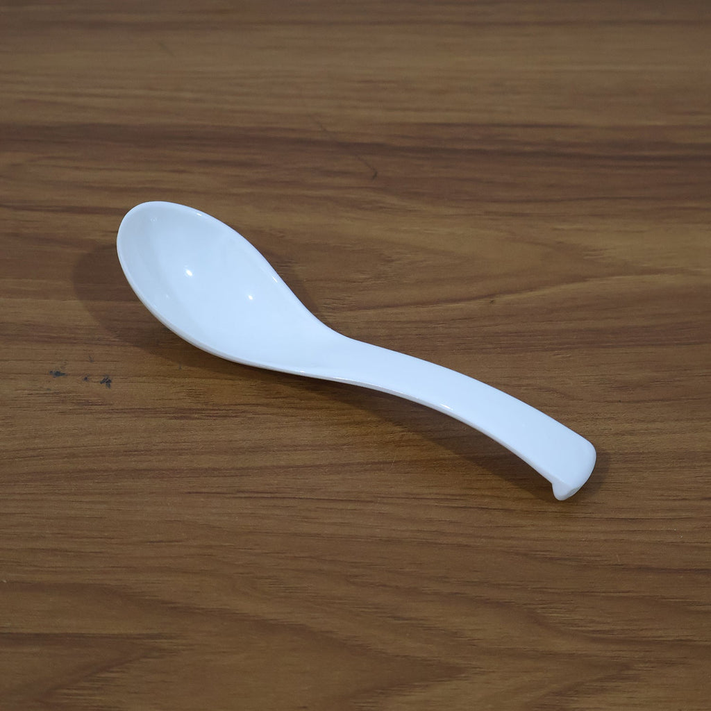Plastic soup spoon in use with soup bowl at table