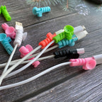 Set of four cable protectors in white, displaying their flexible design and suction ends.