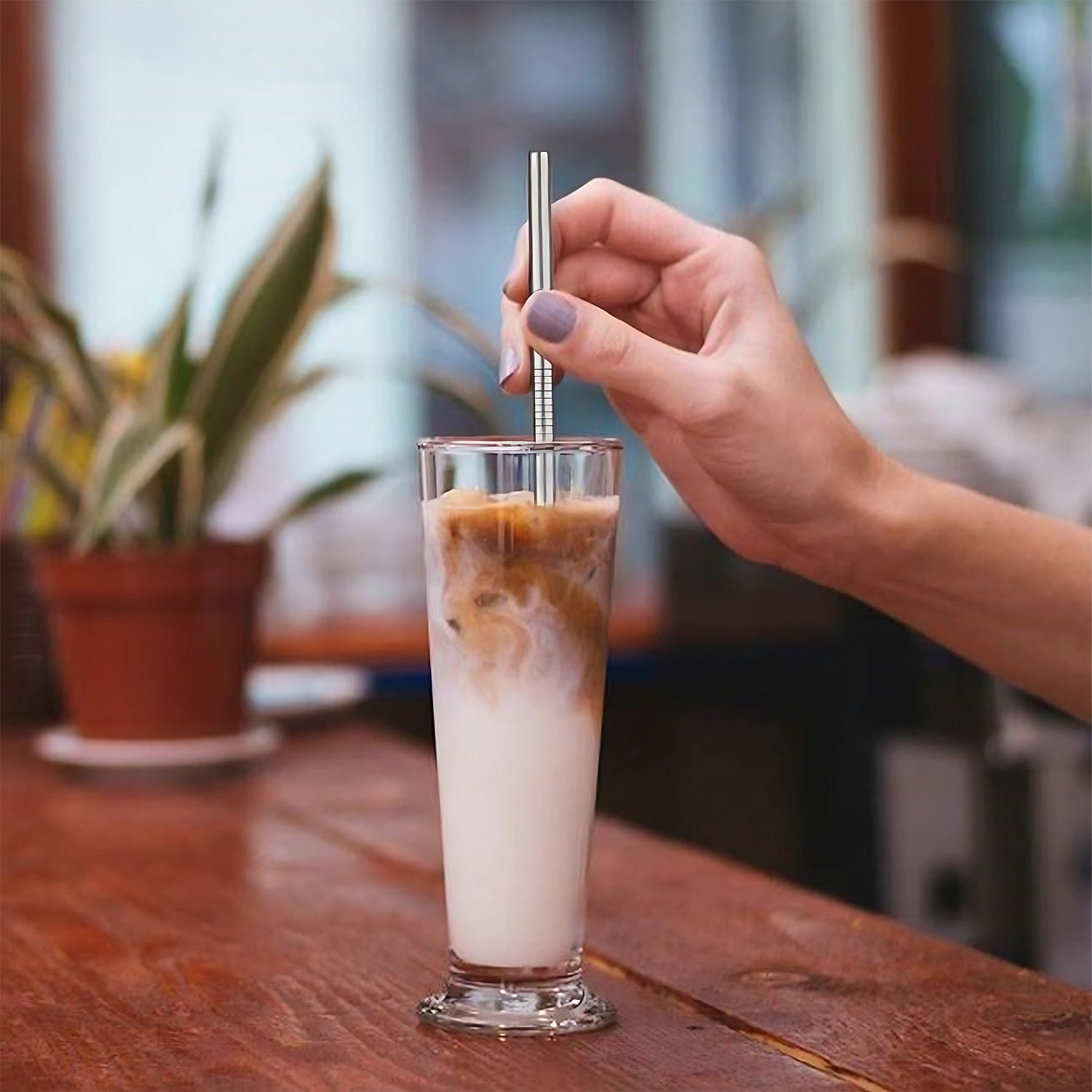 Artful arrangement of straight and bent metal drinking straws on a white surface.