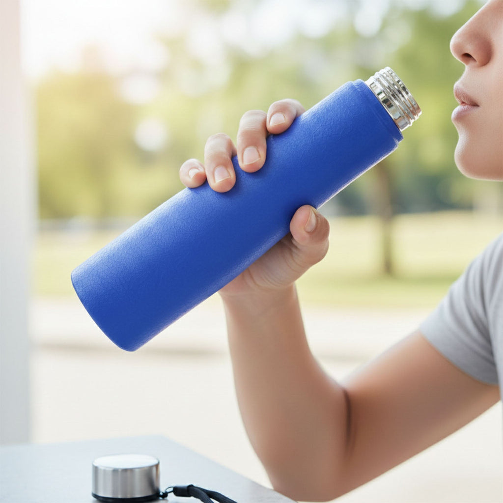 Angled view of blue stainless steel water bottle with carry strap