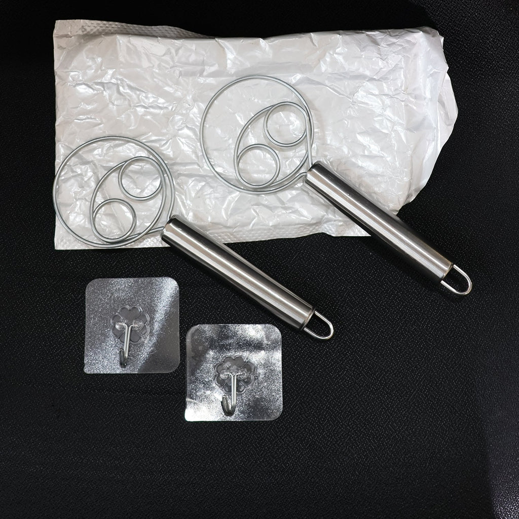 Two stainless steel spiral hand whisks placed on kitchen countertop