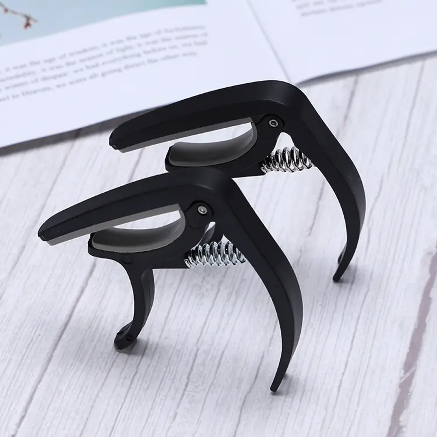 Wagtail guitar capo showcasing its pick holder and soft stand features.