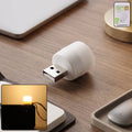 Yellow USB LED night light plugged into a USB port illuminating warm ambient glow